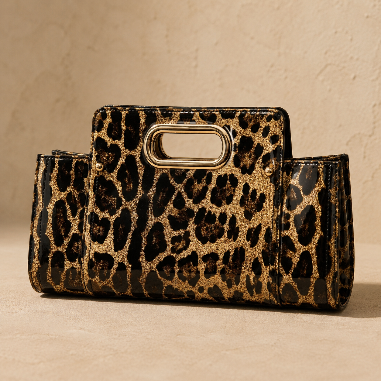 Leopard print clutch with gold handle on a beige background