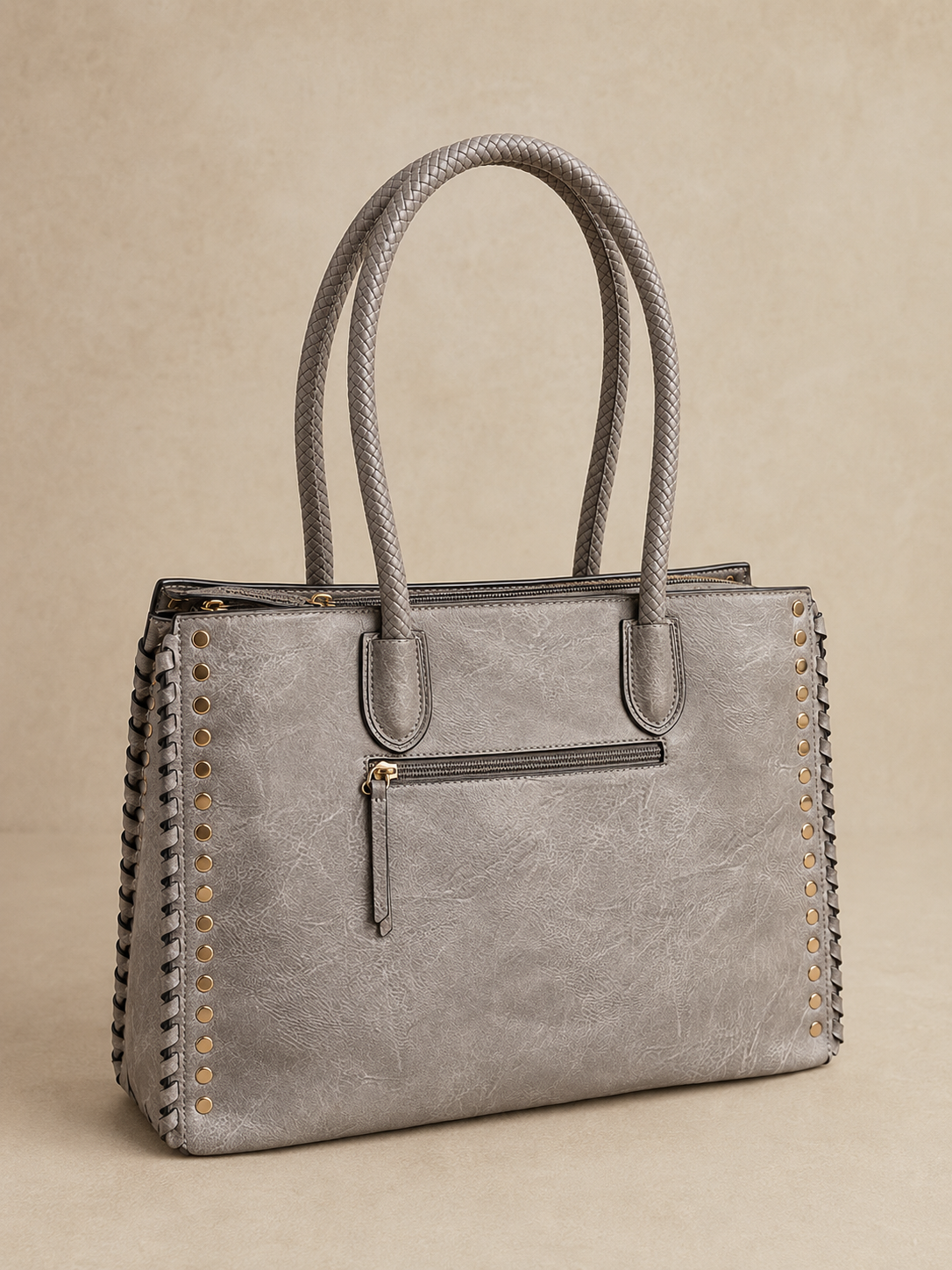 Gray handbag with braided handles on a beige background