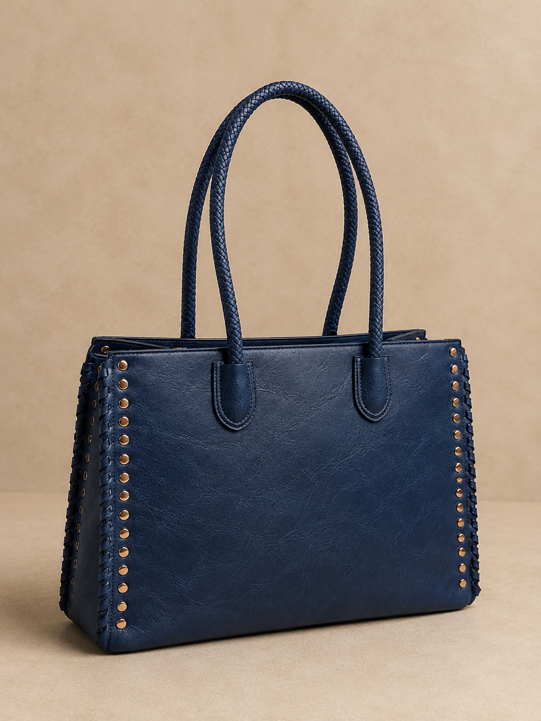 Blue handbag with braided handles on a beige background