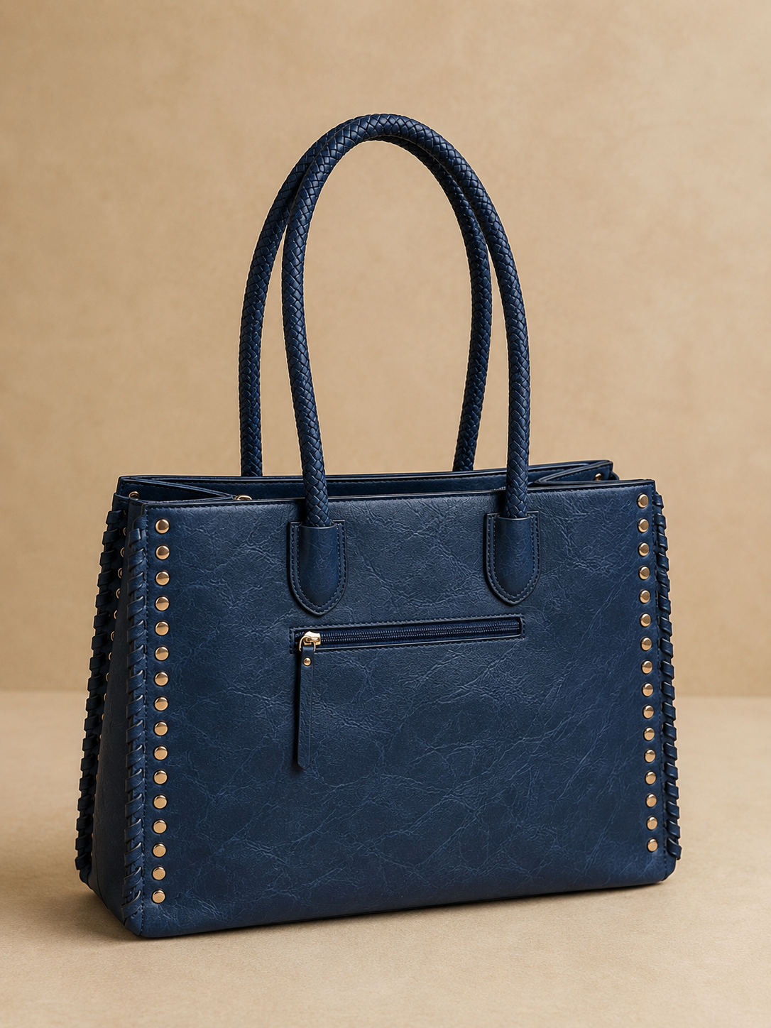 Blue handbag with braided handles on a beige background