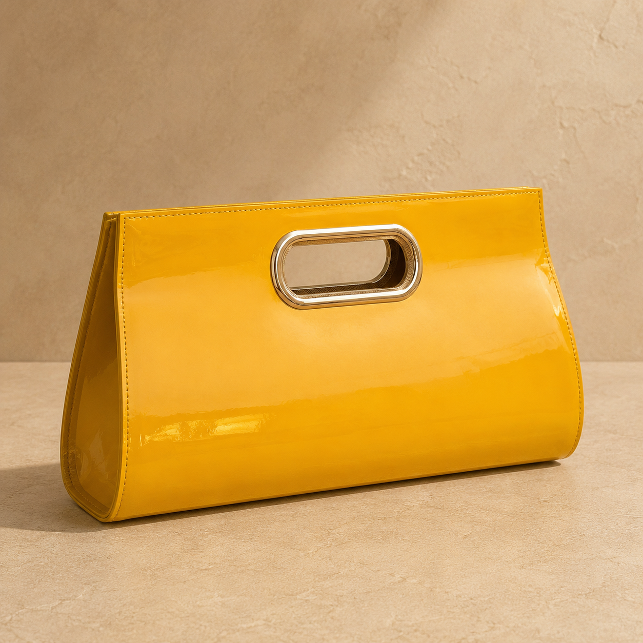 Yellow clutch with a metallic handle on a beige background