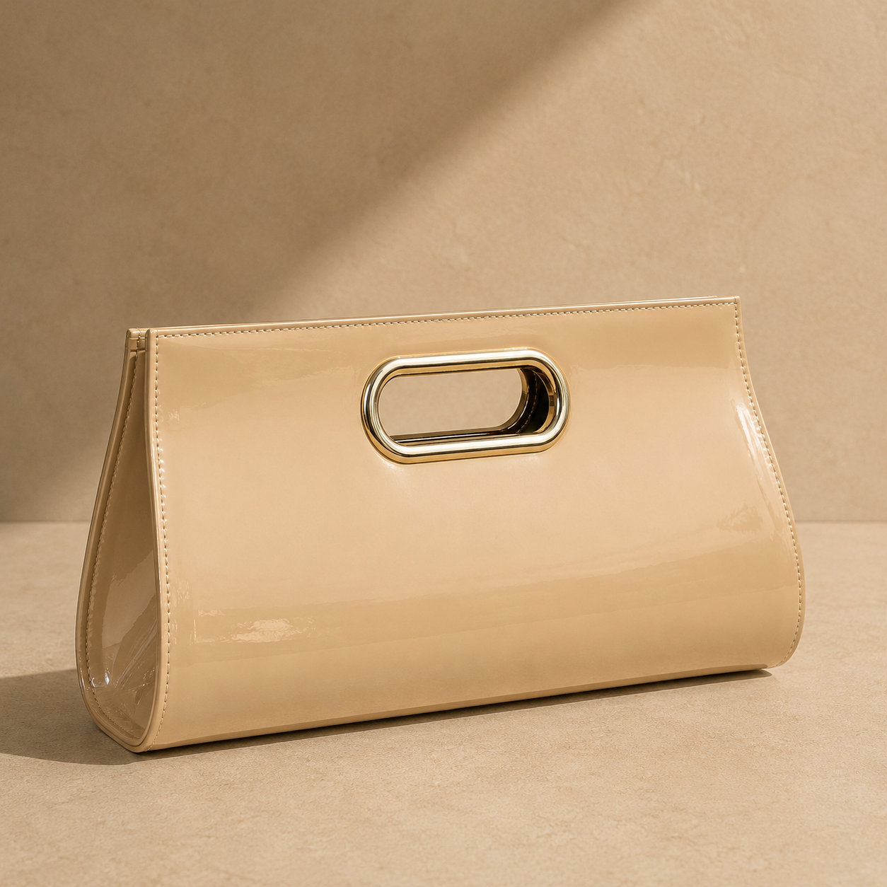 Beige clutch with gold handle on a beige background