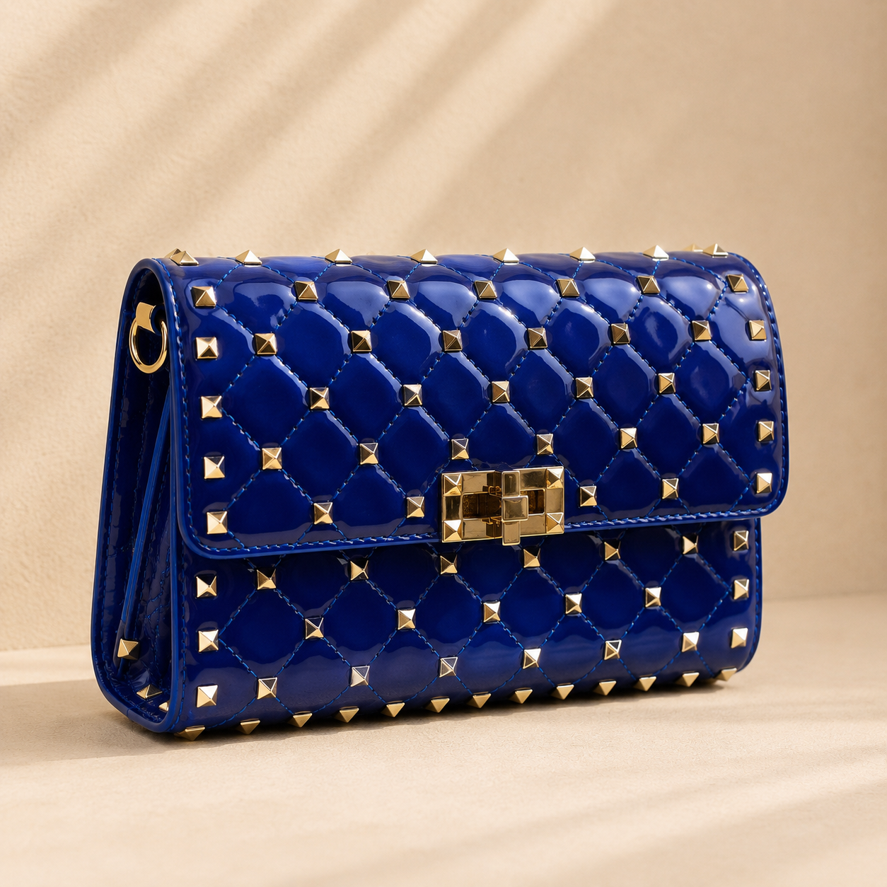 Blue handbag with gold studs on a beige background