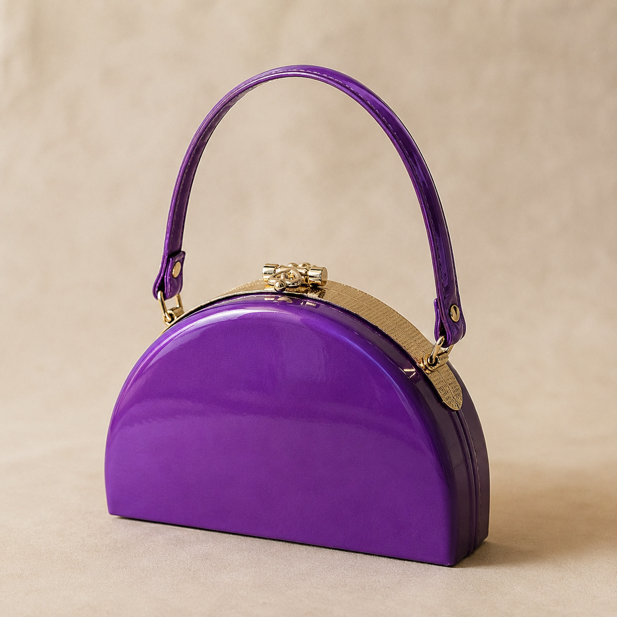 Purple handbag with gold accents on a beige background
