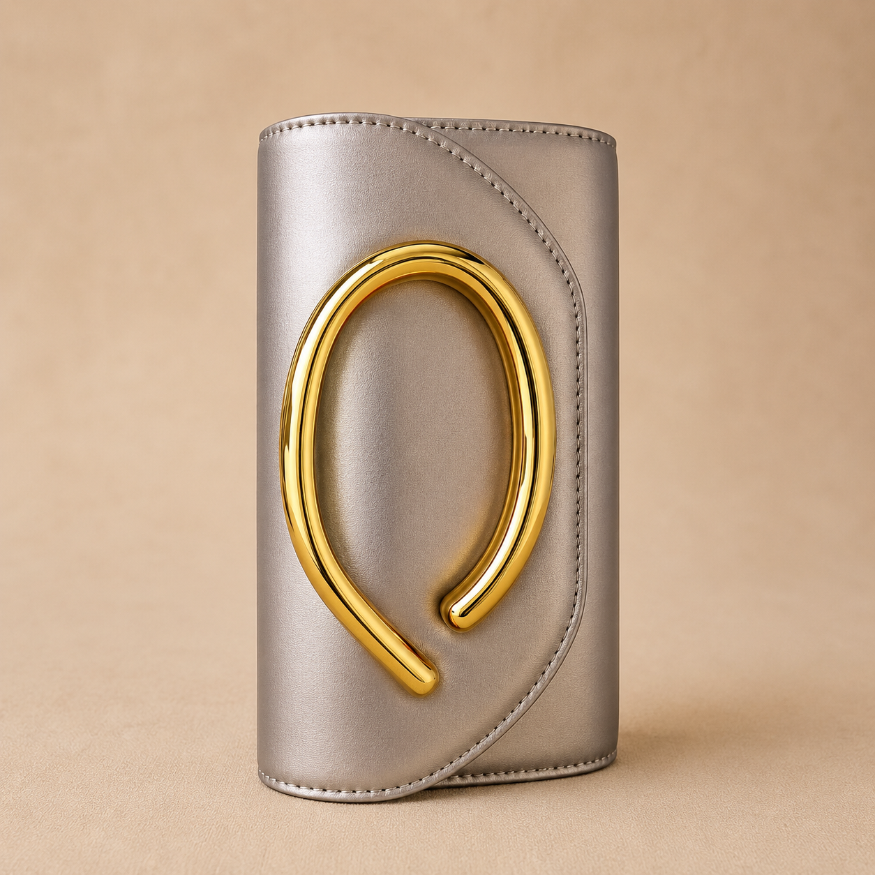 Silver cylindrical object with a gold horseshoe design on a beige background