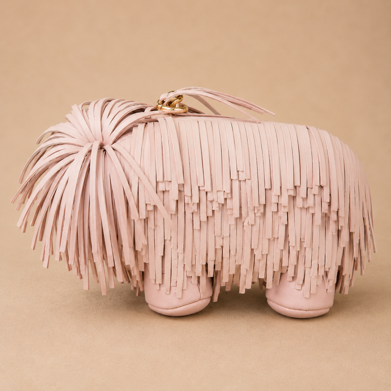 Pink fringed clutch bag on a beige background