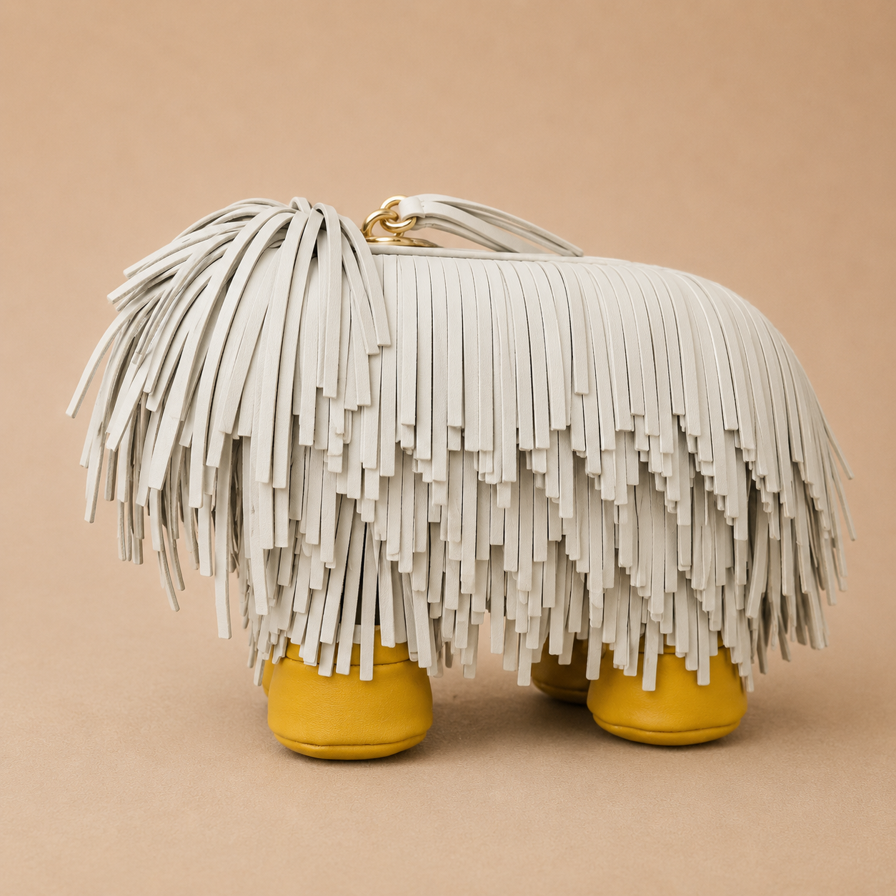 Handbag with white fringe and yellow feet on a beige background