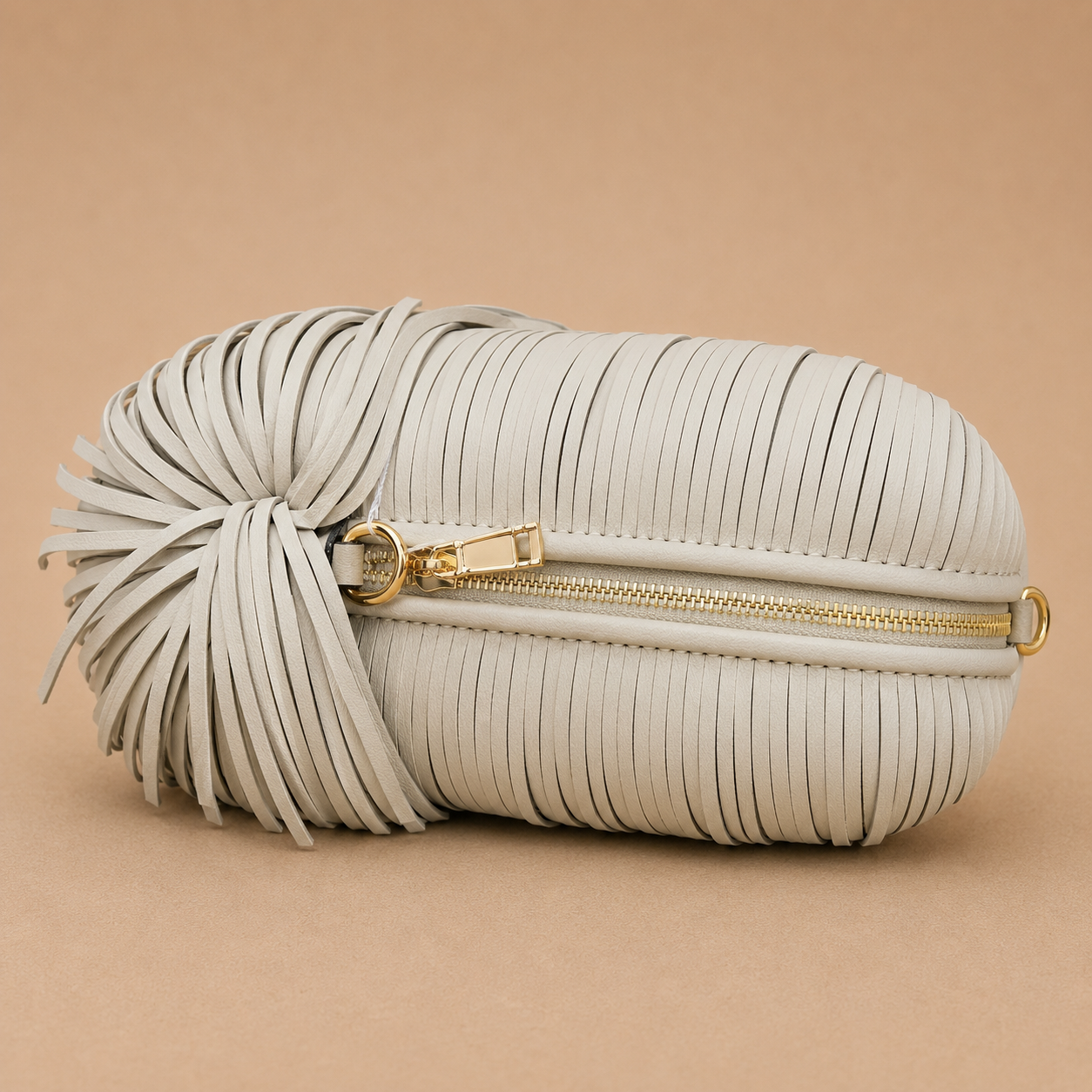 White pleated clutch bag with gold zipper on a beige background