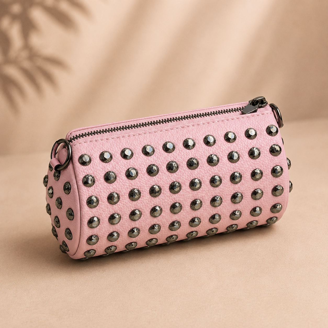 Pink studded clutch on a beige background