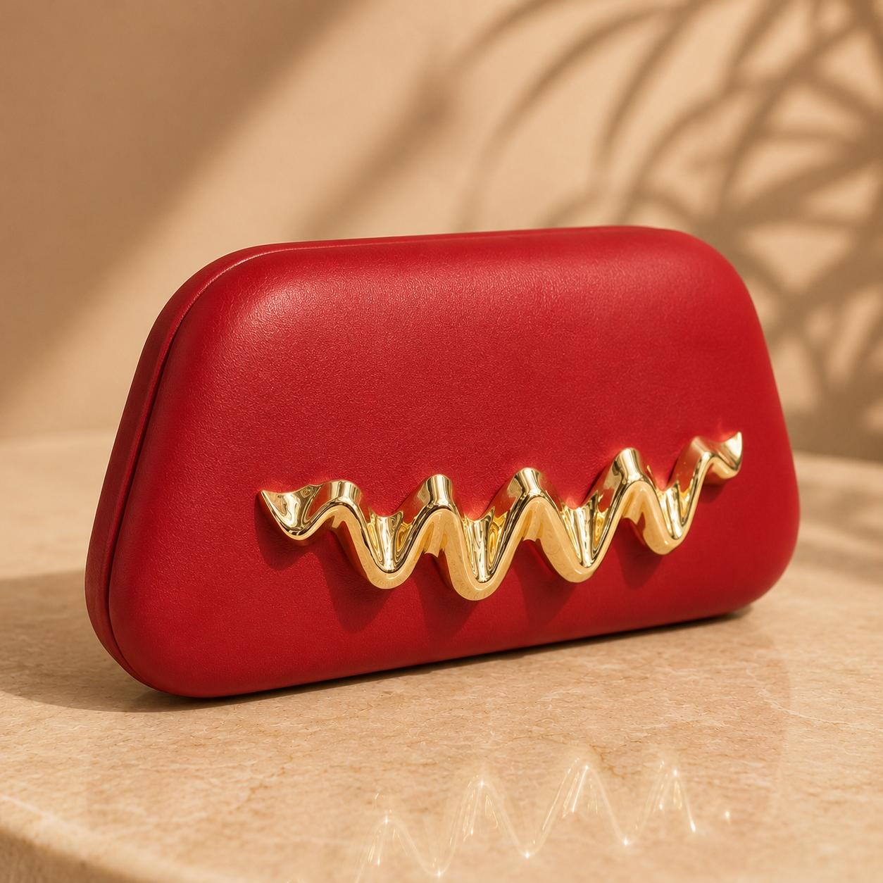 Red clutch with gold embellishment on a beige background