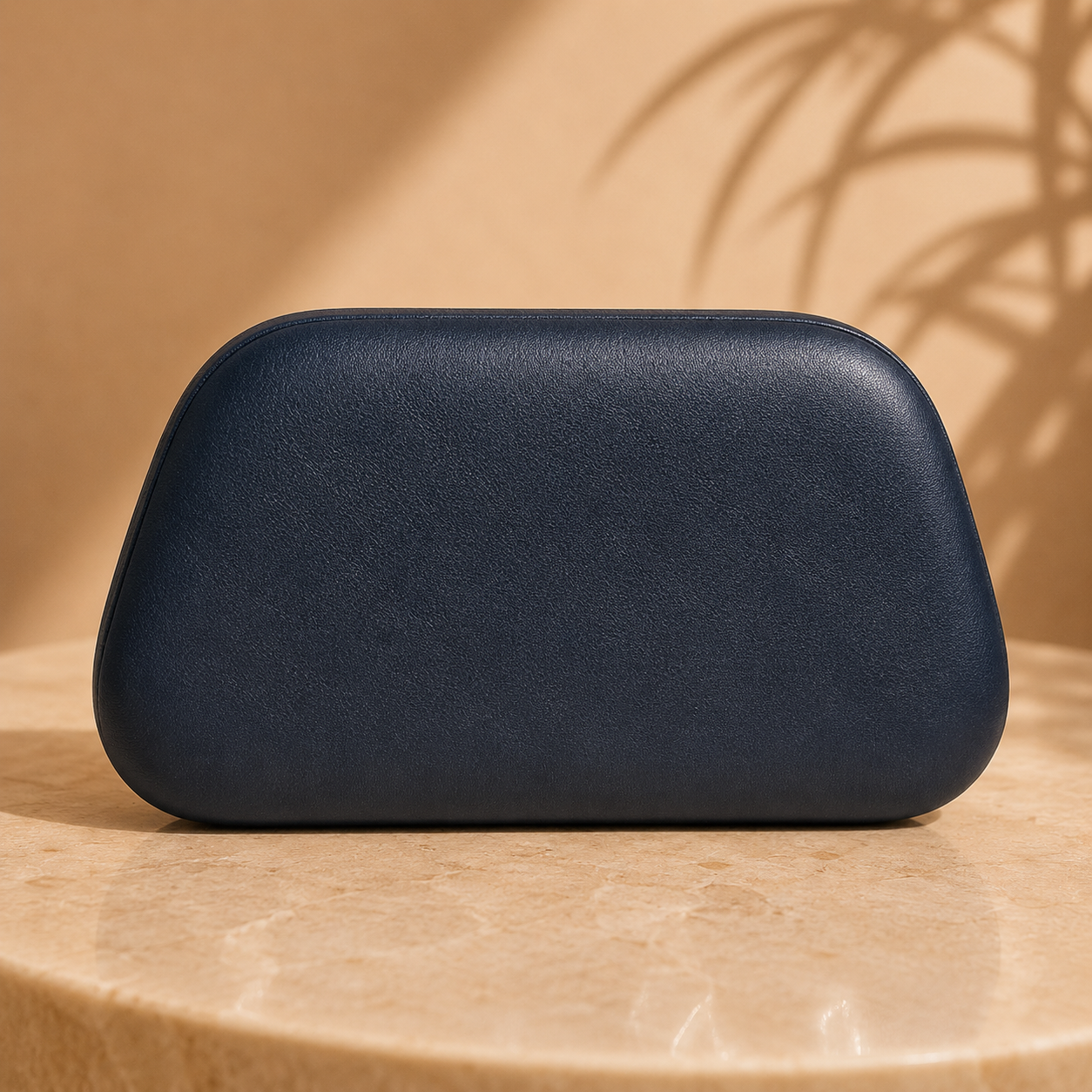Black clutch on a beige surface with a soft shadow