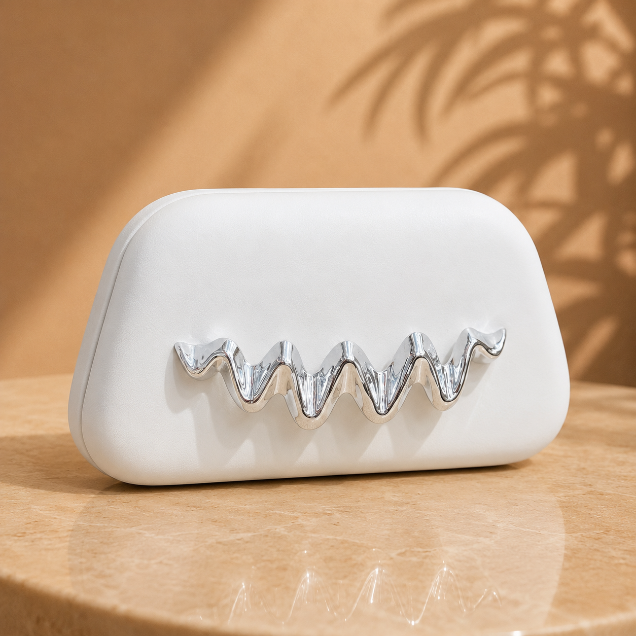 White clutch with silver decorative element on a wooden surface