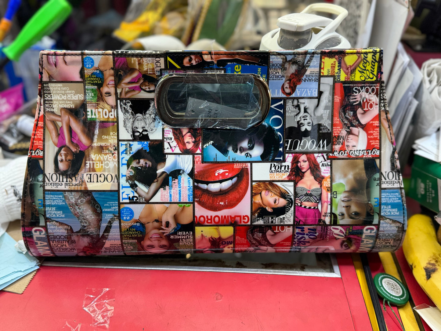 Collage-patterned clutch on a cluttered surface
